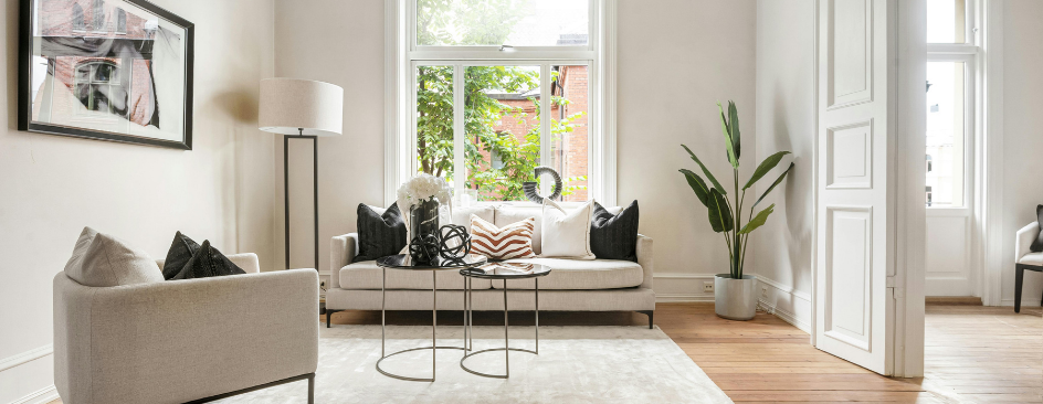 Modern living room with a cream sofa and two round coffee tables.